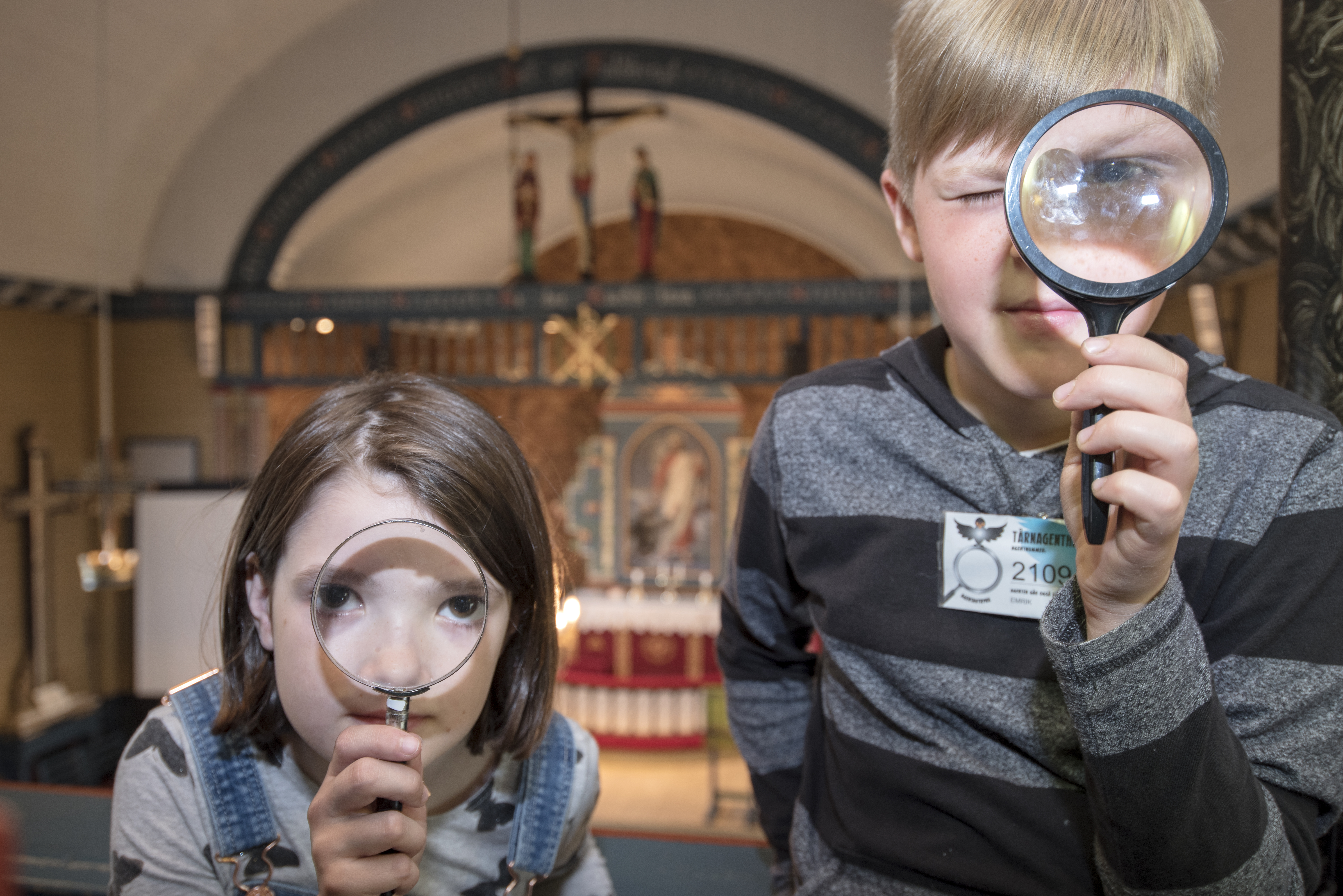 Tårnagenter i kirken med forstørrelseglass